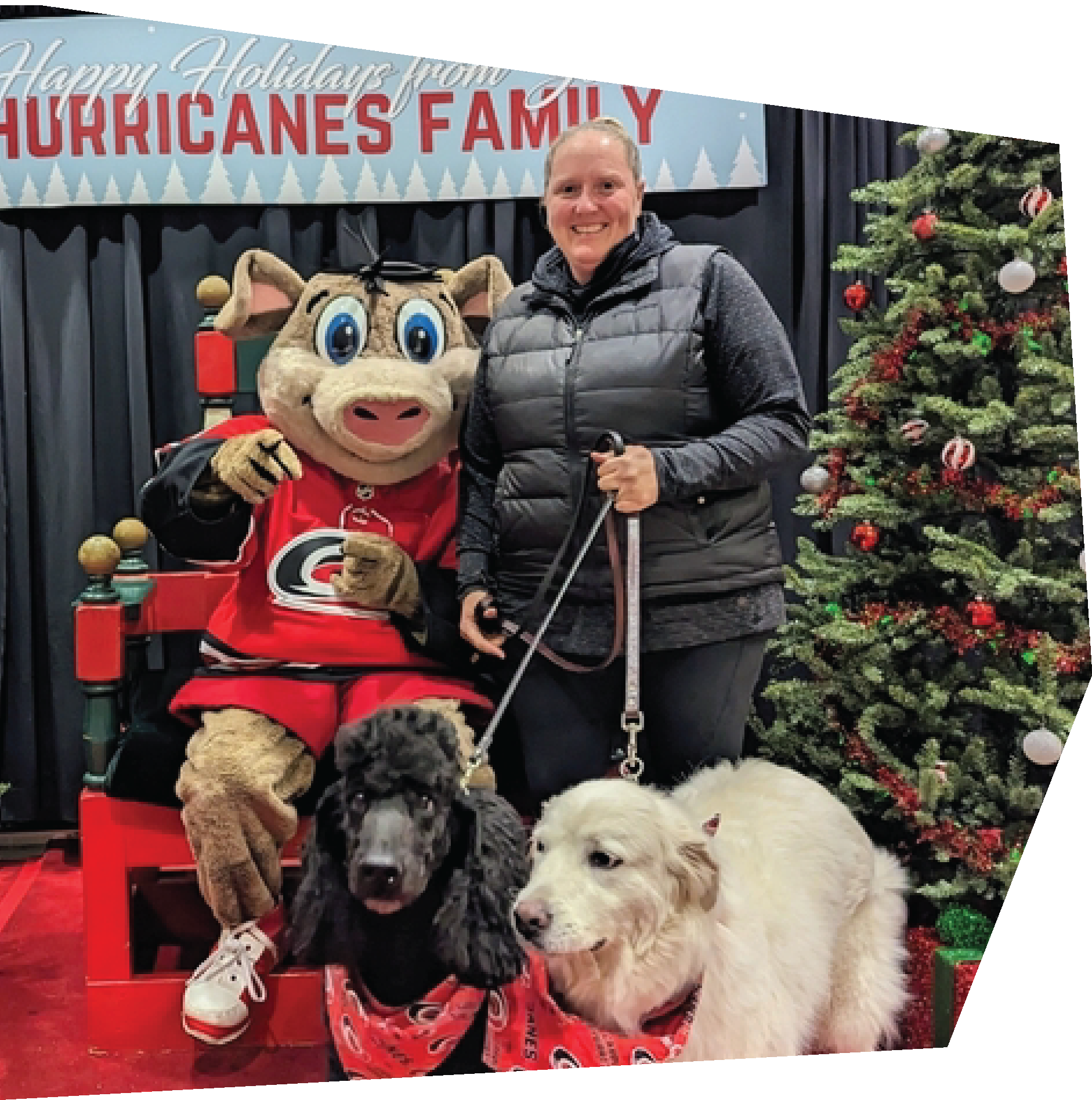 woman with 2 large dogs standing with the Canes mascot